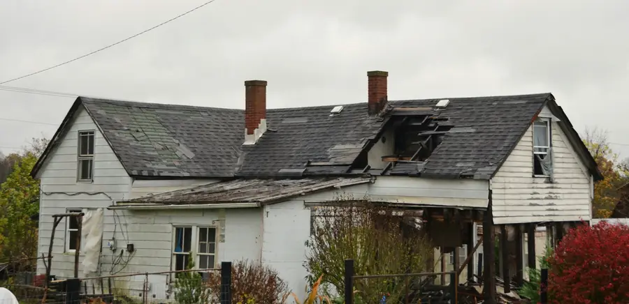 House with a fire damaged roof and exposed framing